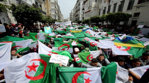 Demonstrators hold flags and banners during anti government protests in Algiers, Algeria April 23, 2019. The banner reads "Government go away - students take over". REUTERS/Ramzi Boudina
