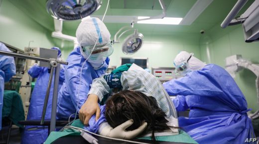This photo taken on March 7, 2020 shows a doctor comforting a pregnant woman, infected by the COVID-19 coronavirus, before her caesarean section at a gynaecology and obstetrics isolation ward in Xiehe hospital in Wuhan in China's central Hubei province. - China on March 8 reported its lowest number of new coronavirus infections since January, with nearly all the 44 new cases in the outbreak epicentre Wuhan. (Photo by STR / AFP) / China OUT