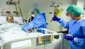 A member of the medical staff gives a thumbs up to a patient as a colleague takes care of him at the COVID-19 division at the ASST Papa Giovanni XXIII hospital in Bergamo, on April 3, 2020. - Italy's three-week lockdown to stop the spread of COVID-19 has been extended through at least mid-April and its economy is expected to suffer its biggest peacetime shock since World War II. (Photo by Piero CRUCIATTI / AFP)