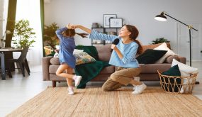 happy family mother and child daughter play at home and sing with combs