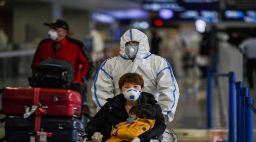 Passengers wearing face masks, amid concerns of the COVID-19 coronavirus, arrive at Shanghai Pudong International Airport in Shanghai in March 19, 2020. - China on March 19 reported no new domestic cases of the coronavirus for the first time since it started recording them in January, but recorded a spike in infections from abroad. (Photo by Hector RETAMAL / AFP);مسافرون في مطار شنغهاي الدولي بالصين