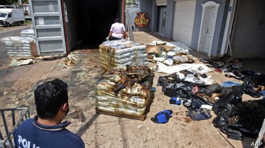 EDITORS NOTE: Graphic content / A policeman and a forensic expert are seen next to parts of decomposed bodies found inside a container coming from Serbia, in Asuncion, on October 23, 2020. - At least seven corpses were found in a fertiliser shipment coming from Serbia. (Photo by DANIEL DUARTE / AFP) / GRAPHIC CONTENT