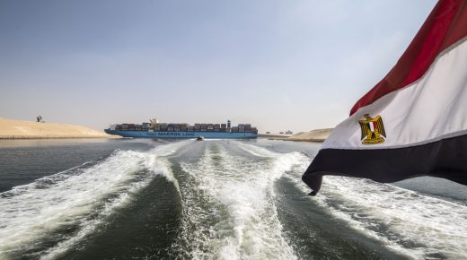 An Egyptian national flag flies on a boat as showsa container ship sails down at the new section of the Suez Canal in the Egyptian port city of Ismailia, 135 kms northeast of Cairo on October 14, 2019. - Since the Suez Canal was inaugurated amid pomp and ceremony 150 years ago, it has become one of the world's most important waterways. But its anniversary will only be discreetly marked in Egypt.
The man-made canal was excavated between 1859 and 1869, in an ambitious project to connect the Mediterranean to the Red Sea, and cut shipping times for growing international trade from Europe to Asia. (Photo by Khaled DESOUKI / AFP) (Photo by KHALED DESOUKI/AFP via Getty Images)