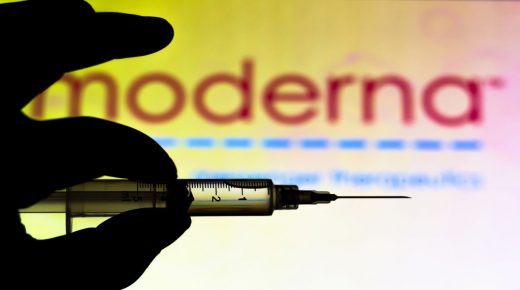 BRAZIL - 2020/11/13: In this photo illustration the medical syringe is seen with Moderna Therapeutics company logo displayed on a screen in the background. (Photo Illustration by Rafael Henrique/SOPA Images/LightRocket via Getty Images)