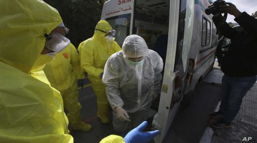 Medics stand outside a clinic where the flight crew as well as several people who were in contact with an Italian man who tested positive for COVID-19 went in for tests, in Algeria, Wednesday, Feb. 26, 2020. The Algerian Health Minister Abderrrahmane Benbouzid announced Tuesday night on state TV the North African nation's first case of the virus, an Italian who is placed in isolation.(AP Photo/Anis Belghoul)