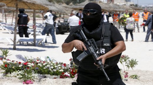 FILE - In this Monday, June 29, 2015 file photo, a hooded Tunisian police officer stands guard ahead of the visit of top security officials of Britain, France, Germany and Belgium at the scene of the shooting attack in front of the Imperial Marhaba hotel in the Mediterranean resort of Sousse, Tunisa. Seven men spent a week in prison on terrorism charges, suffering what they claim was torture under custody, before a judge released them for lack of evidence. But as they stepped out of the courthouse in early August, plainclothes policemen swooped in and spirited them away. (AP Photo/Abdeljalil Bounhar, file)