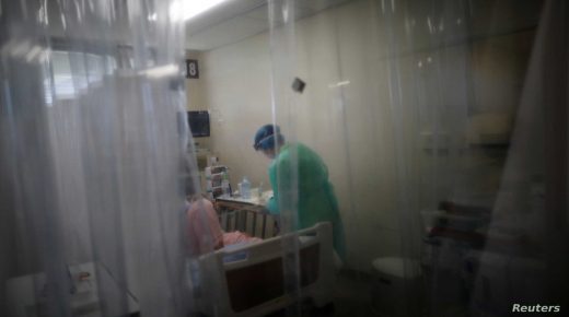 A medical worker wearing personal protection equipment (PPE) treats a patient suffering from the coronavirus disease (COVID-19) in the Intensive Care Unit (ICU) at St. Marianna University Yokohama Seibu Hospital in Yokohama, south of Tokyo, Japan May 25, 2021. Picture taken May 25, 2021. REUTERS/Issei Kato