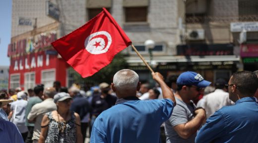 A demonstrator waves the flag of Tunisia as he attends a demonstration held near the building of the Assembly of the Representatives of the People (ARP) in Bardo, Tunis to call for the dissolution of the parliament, a caretaker government of non-partisan competencies and an amendment of the electoral system in Tunisia, on June 14, 2020. (Photo by Chedly Ben Ibrahim/NurPhoto via Getty Images)