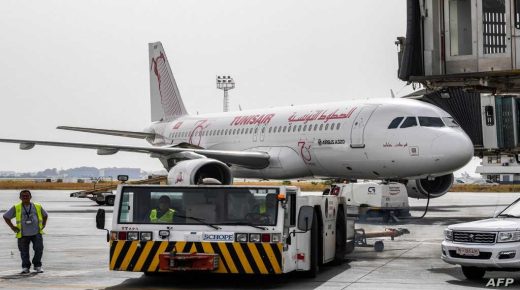 A worker of Tunis-Carthage International Airport drives an aircraft tow tractor past a TunisAir Airbus A320 aircraft on the tarmac at the airport in the Tunisian capital on June 27, 2020 as the North African country re-opens its land, sea, and air borders following a four-month closure due to the COVID-19 coronavirus pandemic. (Photo by FETHI BELAID / AFP)