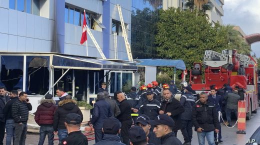 Firemen stand outside the Ennahda party headquarters after a fire broke out at Tunisia's Ennahda Tunisia's moderate Islamist party, Thursday, Dec.9, 2021 in Tunis. (AP Photo/Francesca Ebel)