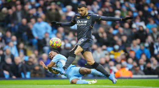 MANCHESTER, ENGLAND - DECEMBER 11: Romain Saiss of Wolverhampton Wanderers competes for the ball whilst under pressure from Raheem Sterling of Manchester City during the Premier League match between Manchester City and Wolverhampton Wanderers at Etihad Stadium on December 11, 2021 in Manchester, England. (Photo by Matt McNulty - Manchester City/Manchester City FC via Getty Images)