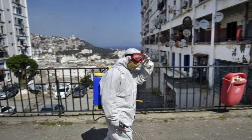 Municipal workers dressed in protective gear disinfect a street during the COVID-19 coronavirus pandemic in the Bab el-Oued district of Algeria's capital Algiers on April 9, 2020. (Photo by RYAD KRAMDI / AFP)