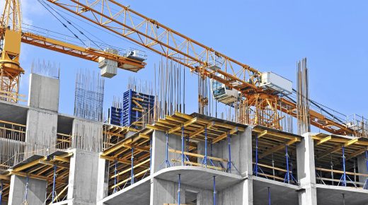 Crane and building construction site against blue sky