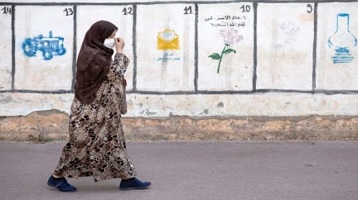 A woman walks past a wall on which are painted the symbols of some of the political parties running for the upcoming elections in the Moroccan capital Rabat, on August, 2021. - The electoral campaign for the legislative, regional and municipal elections set for September 8 began today, a day when nearly 18 million Moroccans, are called to vote to elect the 395 deputies of the House of Representatives and the more than 31,000 municipal and regional elected officials, (Photo by FADEL SENNA / AFP) (Photo by FADEL SENNA/AFP via Getty Images)