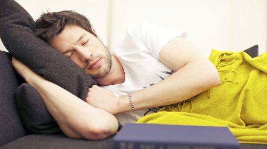 Young Asian man in a deep exhausted sleep after studying from his book.