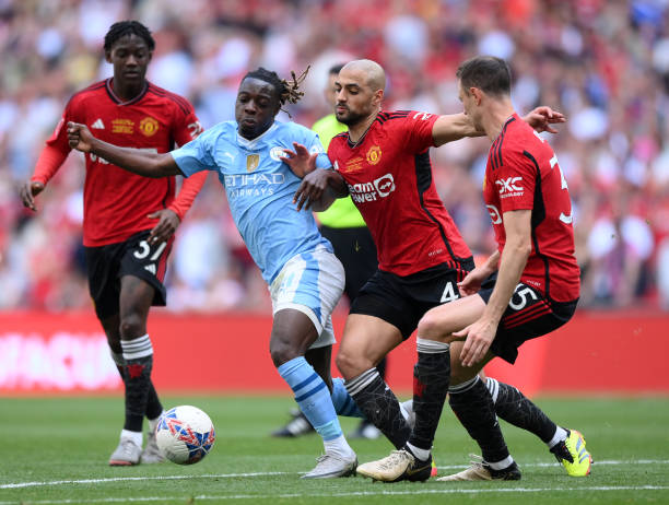 LONDON, ENGLAND - MAY 25: Jeremy Doku of Manchester City and Sofyan Amrabat of Manchester United battle for possession during the Emirates FA Cup Final match between Manchester City and Manchester United at Wembley Stadium on May 25, 2024 in London, England. (Photo by Justin Setterfield - The FA/The FA via Getty Images)
