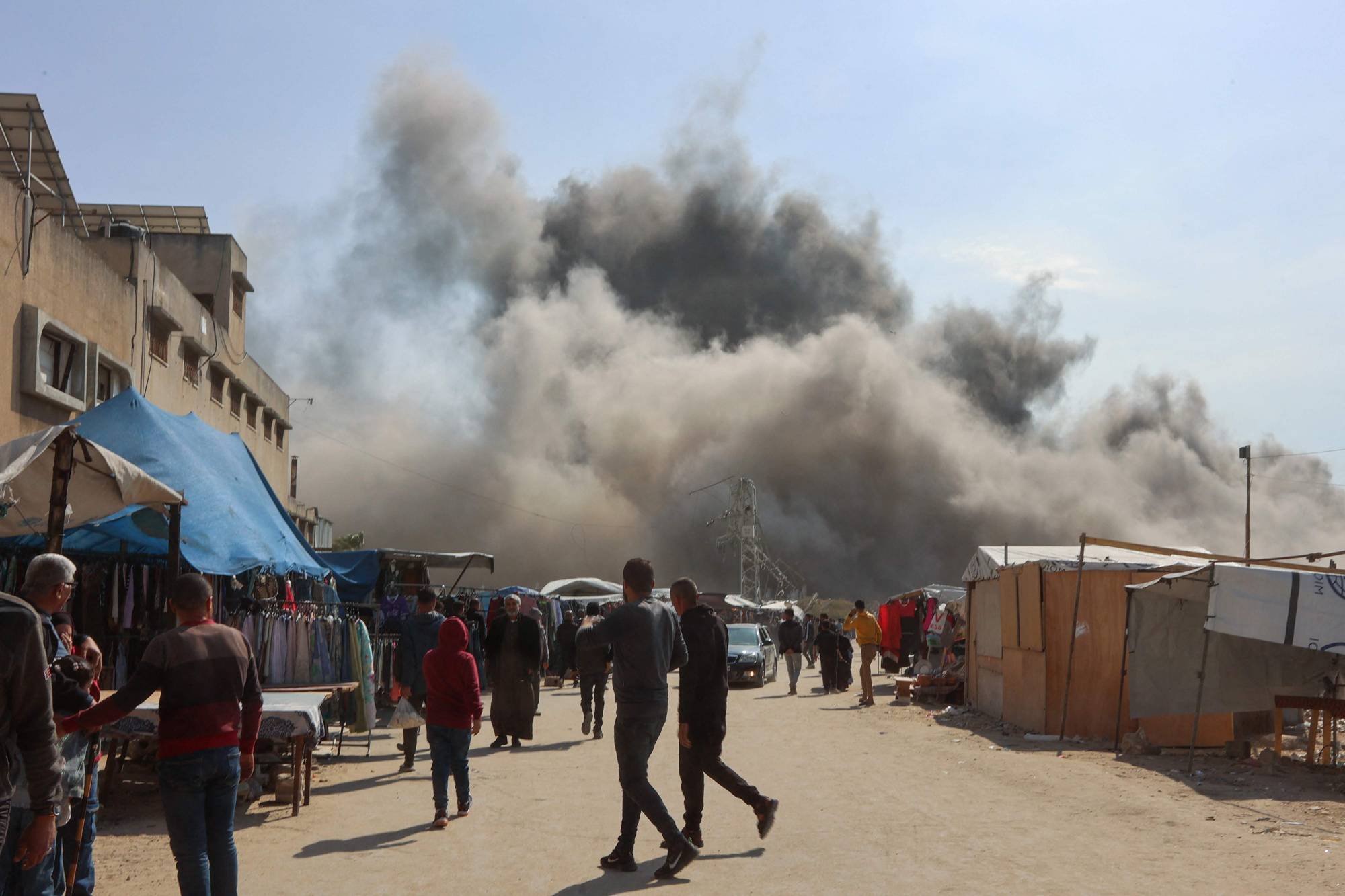 Palestinians look as smoke billows from an Israeli strike on a metalsmith workshop at the Zaytoun neighbouhood in Gaza City on April 13, 2025. (Photo by Omar AL-QATTAA / AFP)