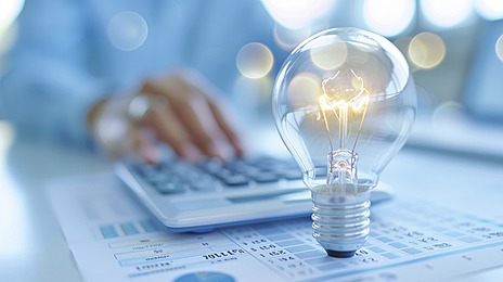 Above the electricity bill is a calculator and a light bulb, representing energy consumption.